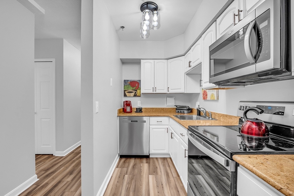 200 Market Street, Unit 117 Lowell, MA 01852 - Photo 2 of 37 a kitchen with stainless steel appliances granite countertop a sink dishwasher stove and cabinets