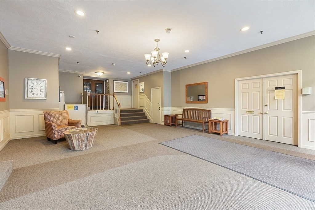 200 Market Street, Unit 117 Lowell, MA 01852 - Photo 30 of 37 a living room with furniture a table and a chandelier