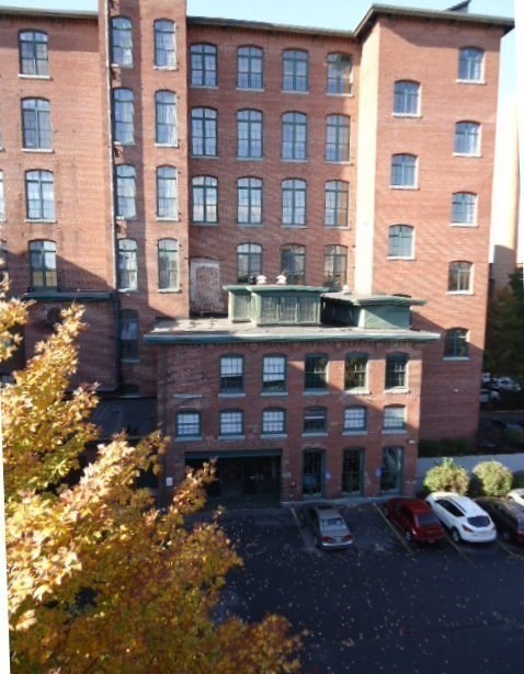 200 Market Street, Unit 117 Lowell, MA 01852 - Photo 34 of 37 a car parked in front of a brick building