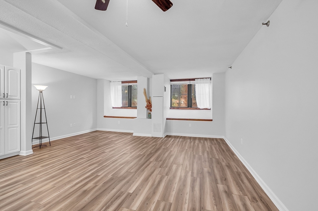 200 Market Street, Unit 117 Lowell, MA 01852 - Photo 4 of 37 a view of an empty room with wooden floor and a window
