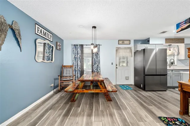 a very nice looking room with a dining table chairs and refrigerator