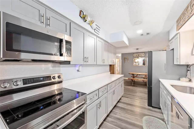 a kitchen with stainless steel appliances a stove microwave and cabinets