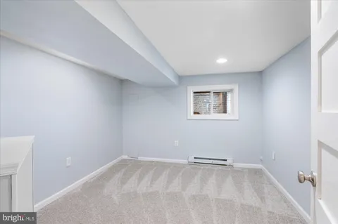 a view of a room with a white wall and a window