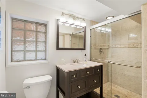 a bathroom with a sink vanity mirror and toilet