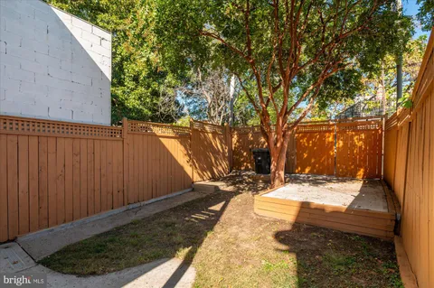 a view of a backyard with wooden fence