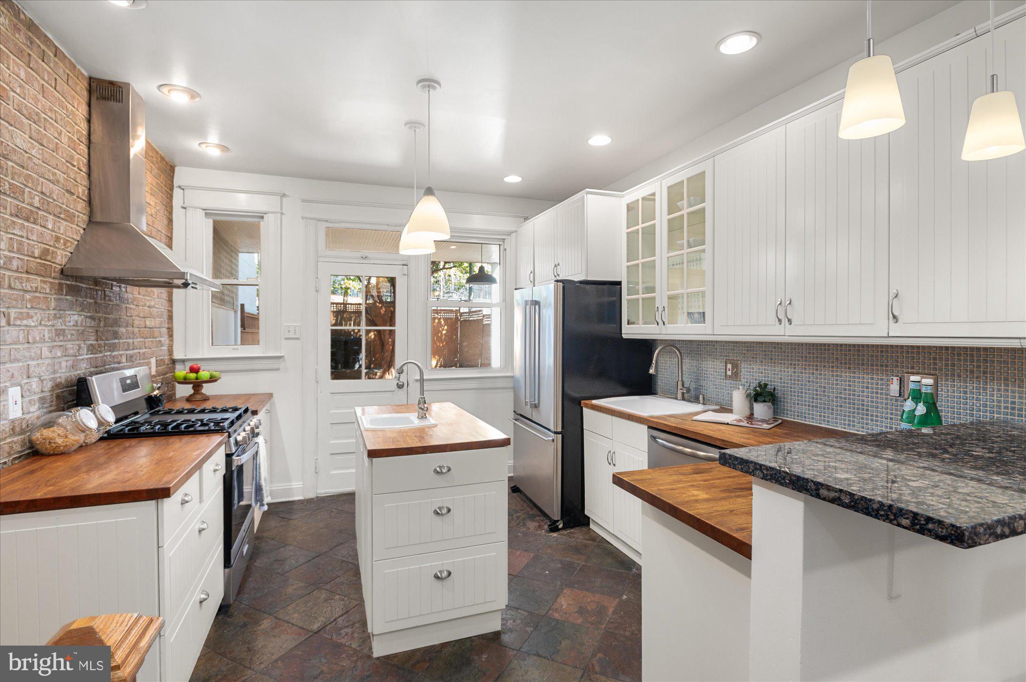 1309 Spring Road Northwest Washington, DC 20010 - Photo 8 of 22 a kitchen with stainless steel appliances kitchen island granite countertop a sink stove and refrigerator