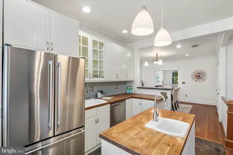 a kitchen with stainless steel appliances granite countertop a refrigerator a sink and a stove