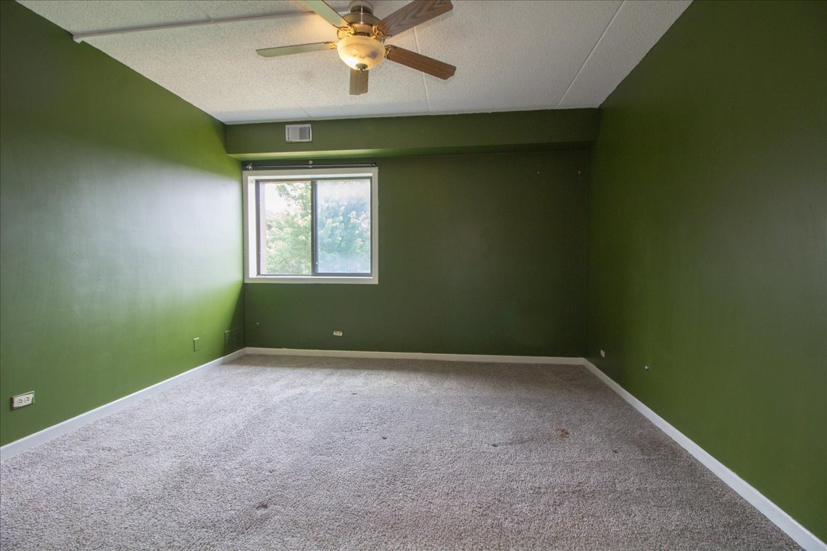 1424 Woodbridge Road, Unit 2C Joliet, IL 60436 - Photo 11 of 20 an empty room with a window and a fan
