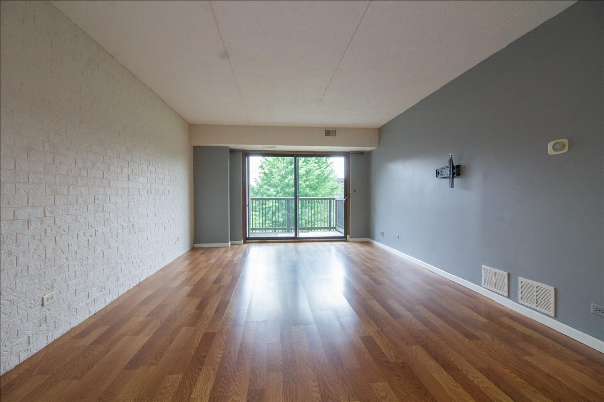 1424 Woodbridge Road, Unit 2C Joliet, IL 60436 - Photo 3 of 20 a view of an empty room with wooden floor and a window