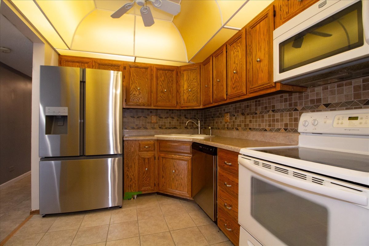 1424 Woodbridge Road, Unit 2C Joliet, IL 60436 - Photo 6 of 20 a kitchen with stainless steel appliances granite countertop a refrigerator a stove and a sink