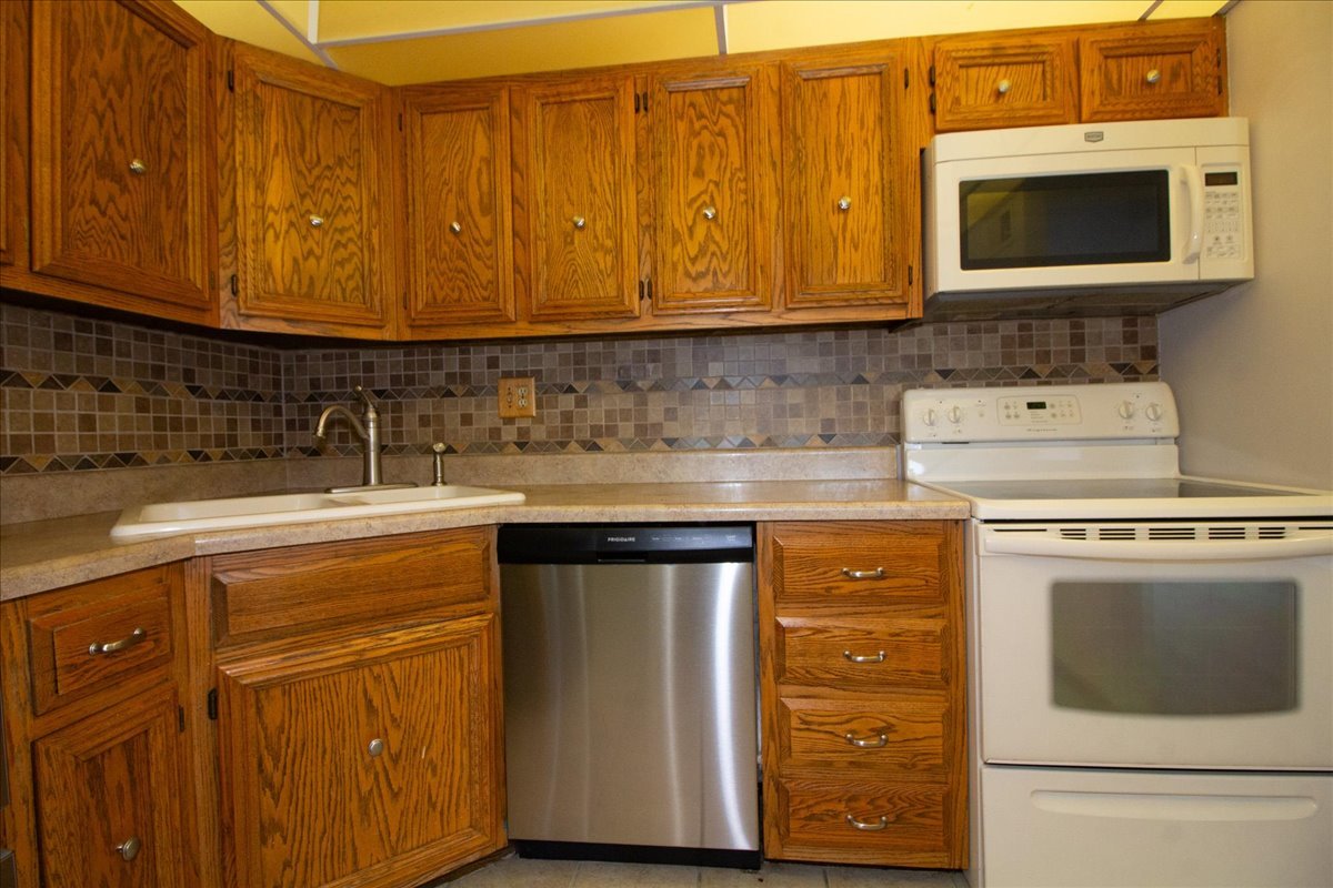 1424 Woodbridge Road, Unit 2C Joliet, IL 60436 - Photo 7 of 20 a kitchen with stainless steel appliances granite countertop a stove microwave and cabinets