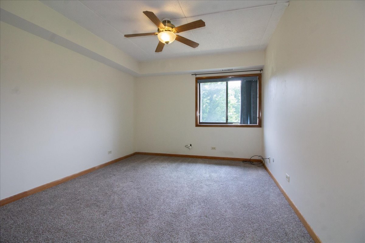 1424 Woodbridge Road, Unit 2C Joliet, IL 60436 - Photo 8 of 20 an empty room with a window and a fan