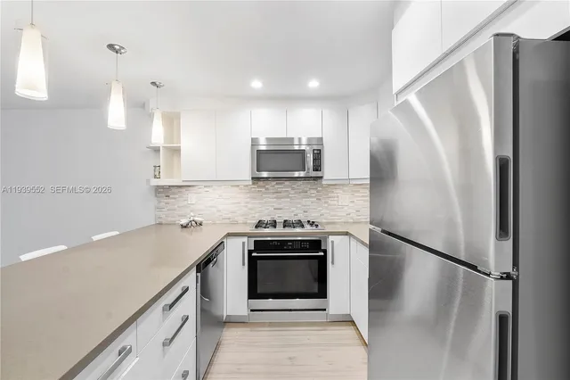 a kitchen with stainless steel appliances a refrigerator sink and microwave