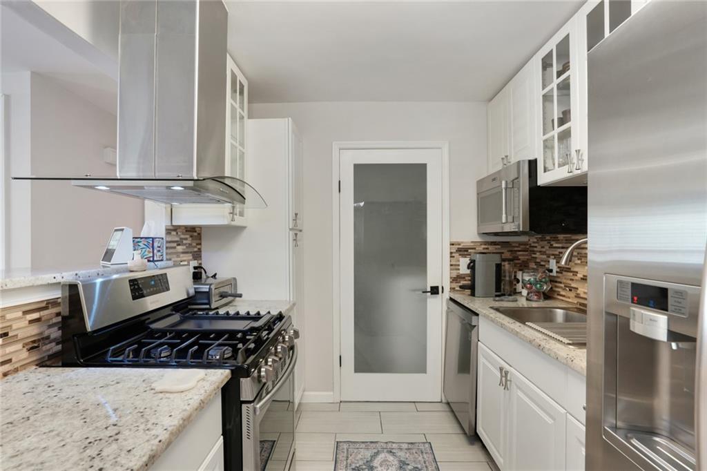3210 Lake Pointe Circle Roswell, GA 30075 - Photo 12 of 26 a kitchen with stainless steel appliances granite countertop a stove oven and a refrigerator