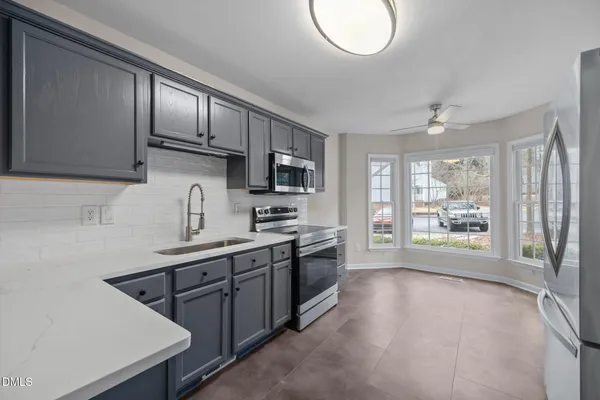 a kitchen with stainless steel appliances granite countertop a refrigerator and a sink