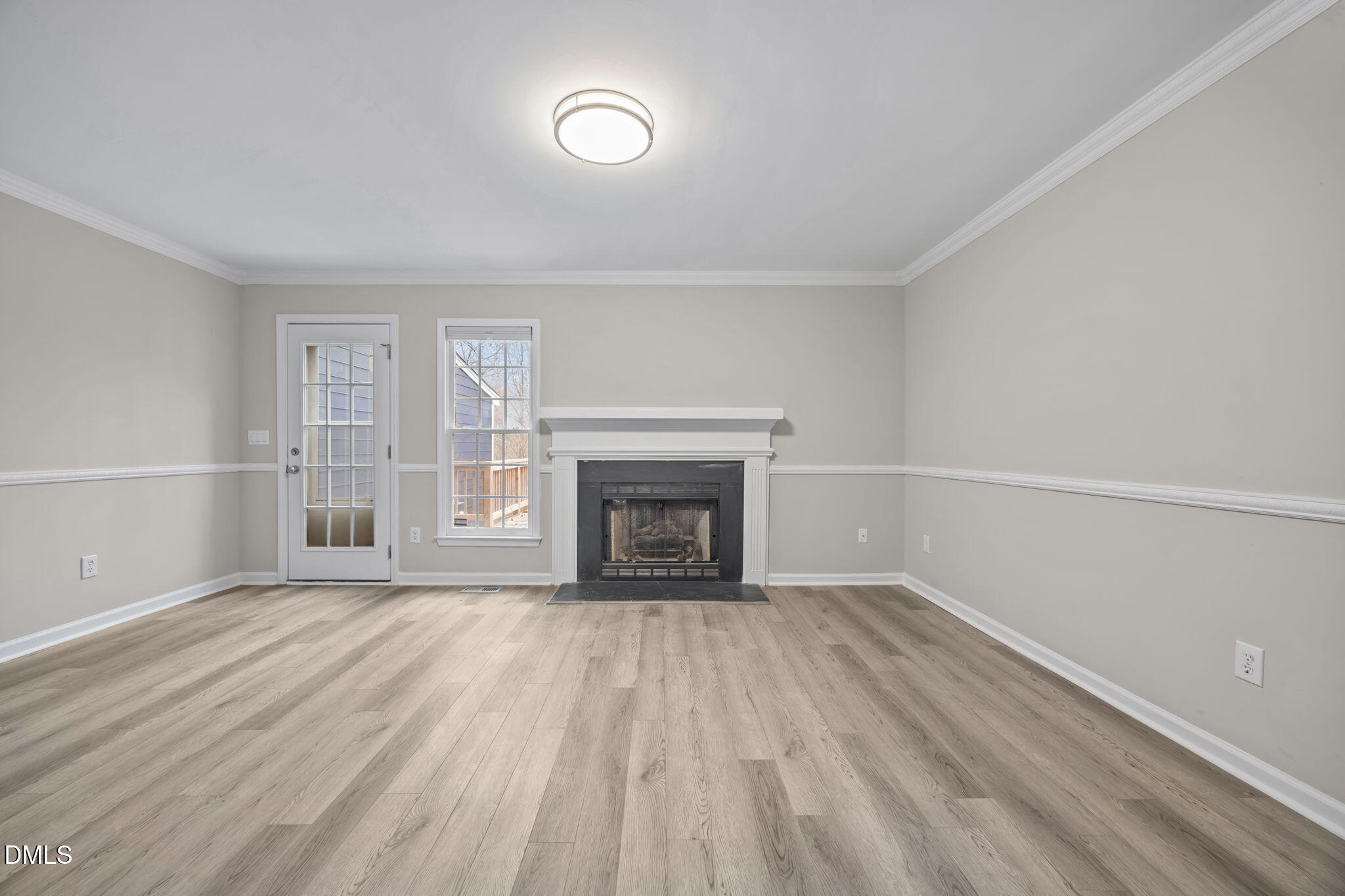 2813 Bedfordshire Court Raleigh, NC 27604 - Photo 5 of 46 a view of an empty room with wooden floor fireplace and a window