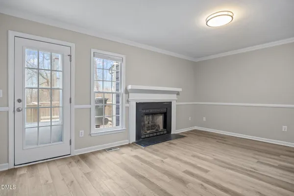 a view of empty room with wooden floor and fireplace
