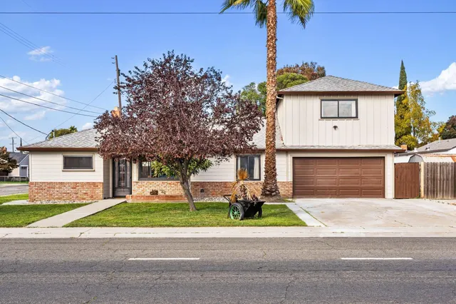 a front view of a house with a garden and plants