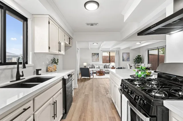 a view of a kitchen from the hallway with a wooden floor