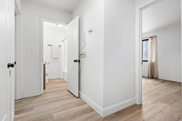 a view of a room that has a window and wooden floor