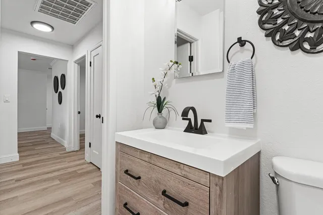 a view of a hallway with wooden floor and staircase