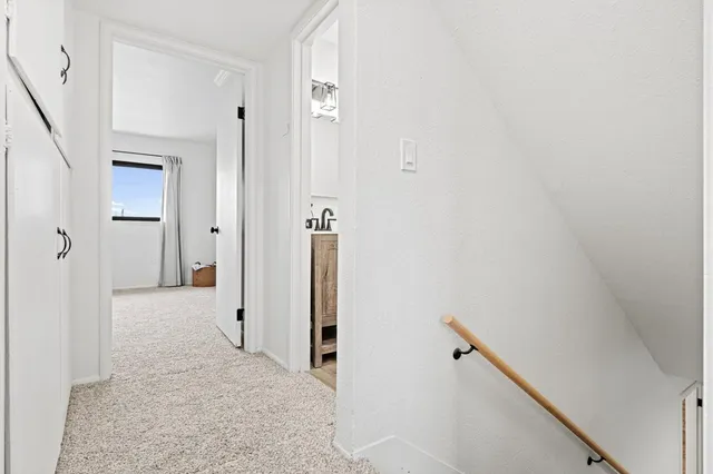 a spacious bedroom with a bed and a lamp