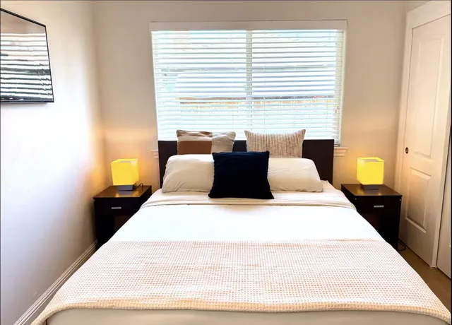 a large bed sitting in a bedroom next to a window