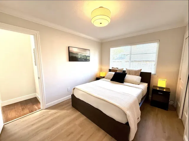 a bed room with a bed mirror and a window