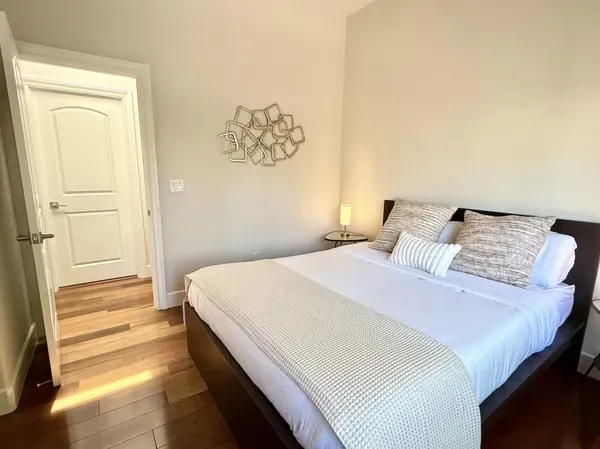 a bedroom with a bed and a painting on the wall