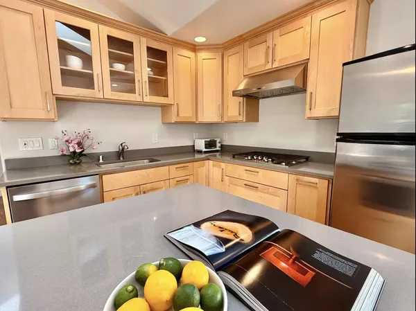 a kitchen with stainless steel appliances granite countertop a stove a sink and a refrigerator