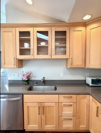 a kitchen with stainless steel appliances granite countertop a sink dishwasher and cabinets with wooden floor