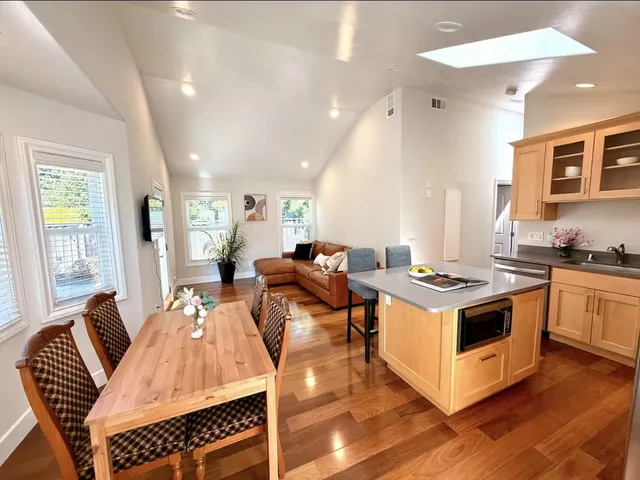 a living room with furniture a large window and a dining table