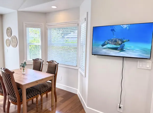 a view of a dining room with furniture a chandelier and wooden floor