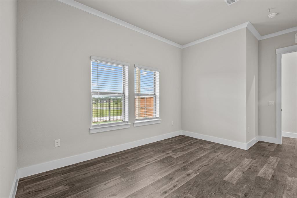 3281 Ganzer Road West, Unit 823A Denton, TX 76207 - Photo 15 of 40 a view of an empty room with wooden floor and a window