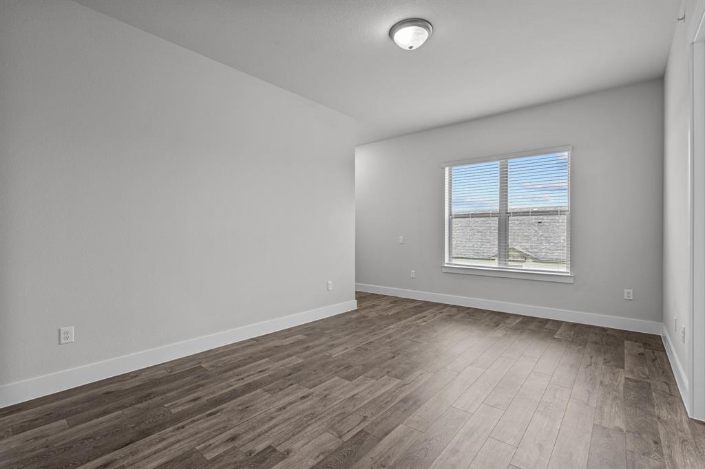 3281 Ganzer Road West, Unit 823A Denton, TX 76207 - Photo 29 of 40 an empty room with wooden floor and windows