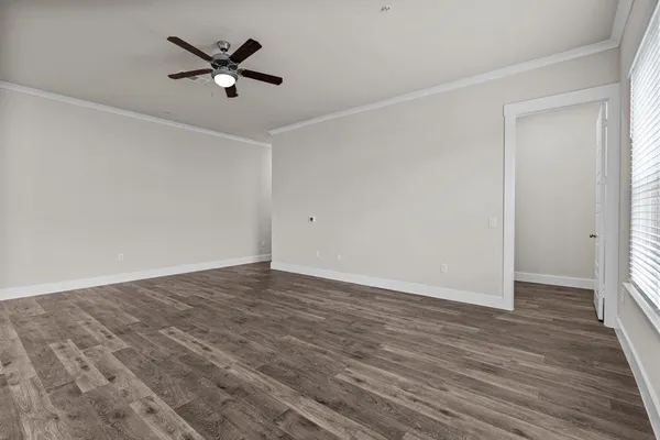 a view of a room with wooden floor and a ceiling fan