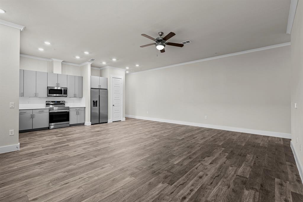 3281 Ganzer Road West, Unit 823A Denton, TX 76207 - Photo 5 of 40 a view of a kitchen with a stove cabinets and wooden floor