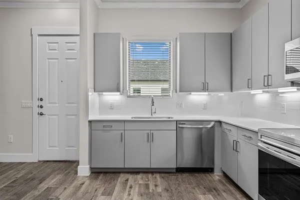 a view with granite countertop a sink and a stove