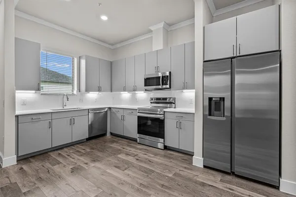a kitchen with a refrigerator a sink and a stove top oven