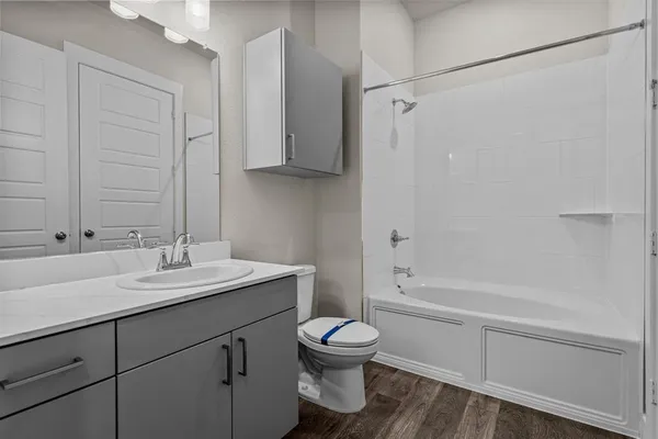 a bathroom with a granite countertop sink toilet a mirror and shower