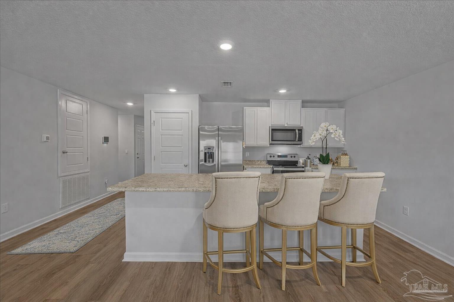 5872 Belmont Stakes Road Pensacola, FL 32526 - Photo 11 of 31 a kitchen with stainless steel appliances granite countertop a table and chairs