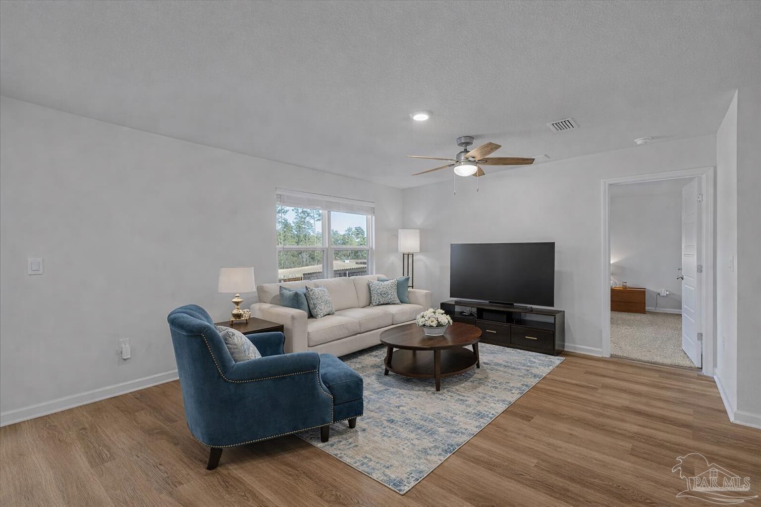 5872 Belmont Stakes Road Pensacola, FL 32526 - Photo 9 of 31 a living room with furniture and a flat screen tv