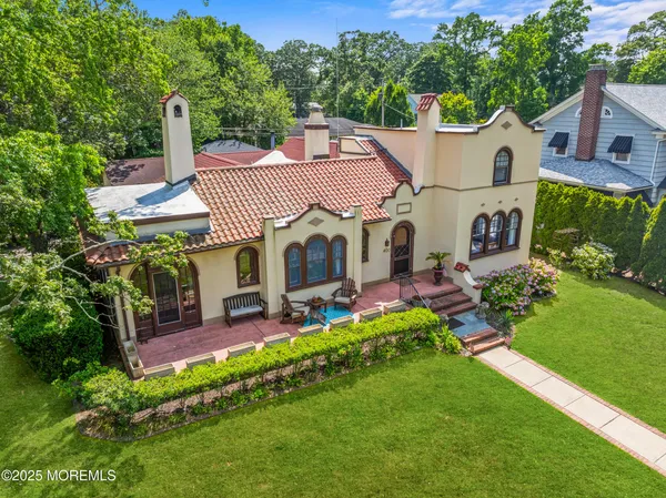 an aerial view of a house having patio with a garden