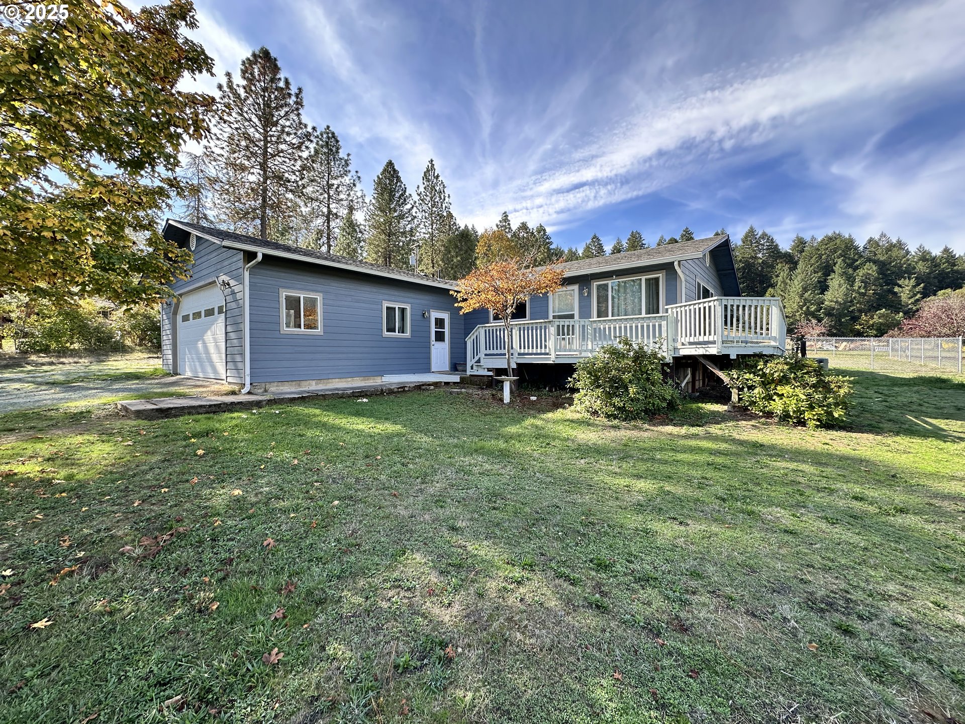a view of a house with a big yard plants and large trees