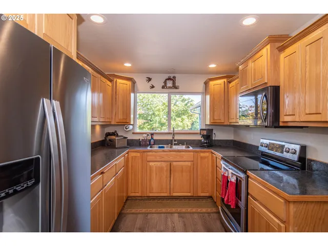 a kitchen with stainless steel appliances granite countertop a refrigerator and a sink
