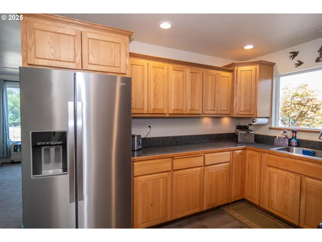 a kitchen with stainless steel appliances granite countertop a sink a stove a microwave a counter space and cabinets