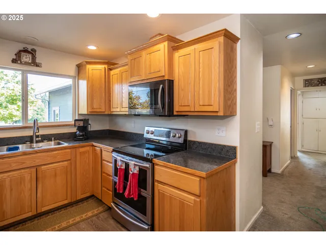 a kitchen with kitchen island granite countertop a sink appliances cabinets and a counter top space