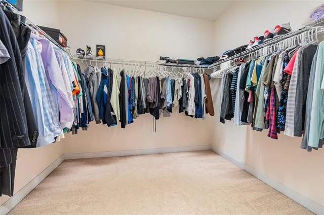 a view of walk in closet with clothes