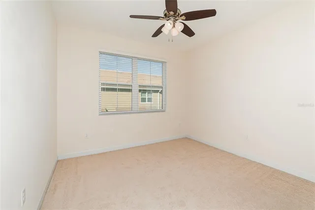 an empty room with a window and a fan