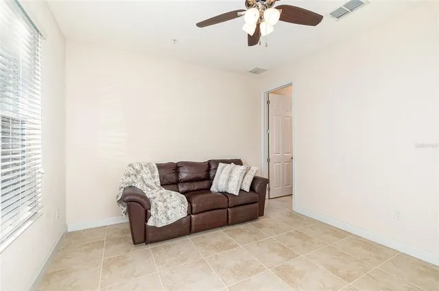 a living room with furniture and a ceiling fan